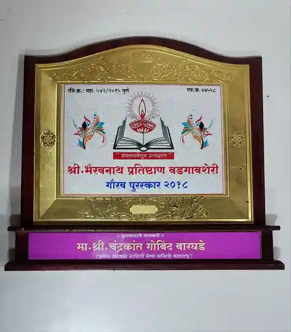 The central area displays the (Shri Bhavyanath Pratishthan Bahuuddeshiy) along with the title (Govil Puraskar 2016), indicating the award's name and year.
The design includes a decorative illustration of a lamp and colorful motifs, symbolizing enlightenment and celebration.
At the bottom, there is a nameplate that reads (Ma. Shri. Radhakant Govind Waghade), identifying the recipient of the award.