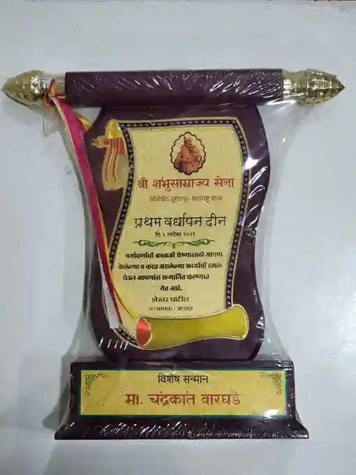 The central part of the plaque displays a cream-colored certificate with the (Shri Abhyudaya Samaj Seva) prominently featured, indicating the organization presenting the award.
The main title reads (Pratham Vardhapan Din), which translates to First Anniversary, along with the date (26 November 2016).At the bottom, there is a nameplate that identifies the recipient as (Ma. Chandrakant Waghade), indicating the individual being honored.