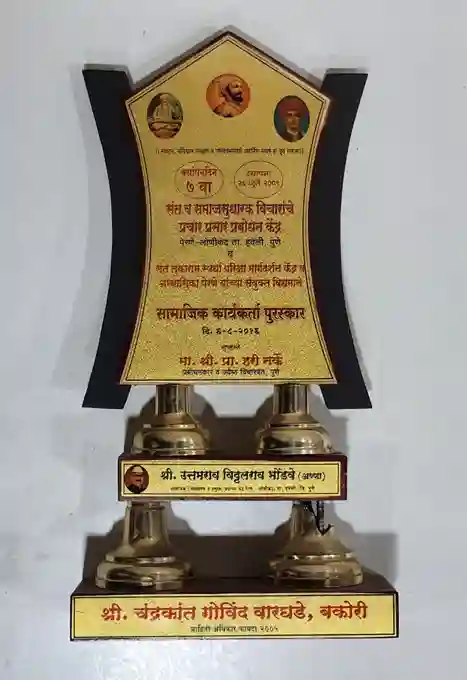 indicating that this is a (Social Worker Award) presented on a specific date. The award recognizes contributions to social work or community service.
At the base of the trophy, there is a nameplate that reads (Shri. Chandrakant Govind Waghade), identifying the recipient. The overall design is elegant and conveys a sense of honor and recognition for significant achievements in social service.