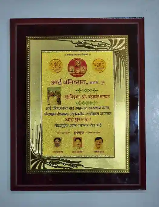 there is a circular emblem, likely representing a significant organization or event. The (Adarsh Pratishthan, Pune), indicating the awarding organization.
The central section highlights the recipient's name, (Subhashak. Ma. Shri. Chandrakant Waghade), along with a description of the award's purpose, which relates to contributions in a specific field or community service.